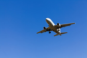 Low Flying Jet Plane In Clear Blue Sky With Landing Gear Down