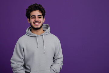 Obraz premium Student in hoodie and sweatpants against purple background with confident smile