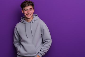 Obraz premium Student in hoodie and sweatpants against purple background with confident smile