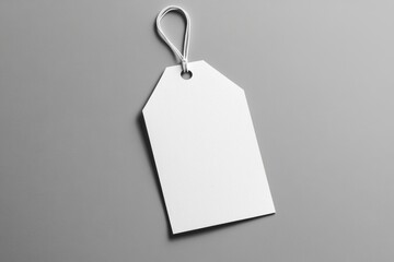 Minimalist mockup of a white paper hang tag against a smooth gray background, ideal for branding and product labeling