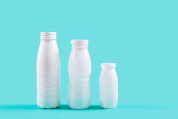 White plastic bottles standing against a blue backdrop, presenting a vibrant contrast and drawing attention to eco-friendly packaging solutions.