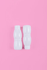 Top view of plastic bottles on pink background, representing a commitment to zero waste living and eco-friendly habits.
