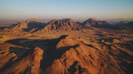 Fototapeta premium An aerial view of a desert mountain range with a blue sky in the backdrop