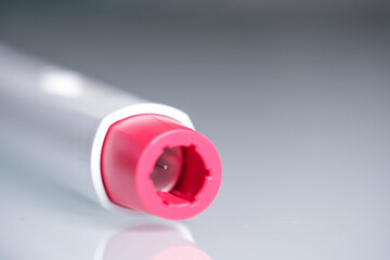 Detail of the head of a pen injector with a red tip for biological treatments such as Adalimumab,...