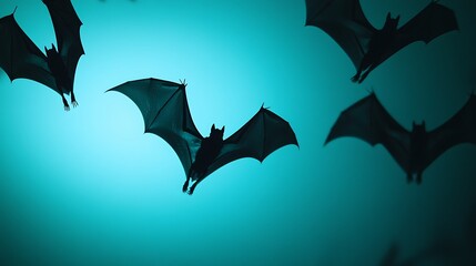 Fototapeta premium Silhouette of bats flying against a blue sky.