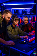 Gamer girl with headset playing video game while her friends helping. © Zamrznuti tonovi
