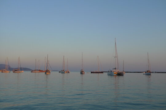 Some sailboats are anchored in the new marina of Pythagorion, in Samos island, Greece during a colorful sunset