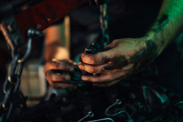 Close-up view of a man's hands working on a mechanical part