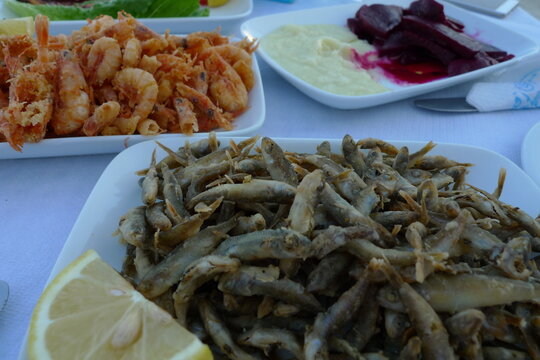 Fresh fried anchovies and other delicacies served on white plates, Leros, Greece