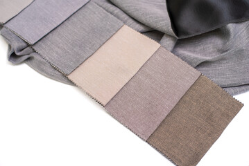 Samples of milk, beige and gray fabric for curtains with black back on white background