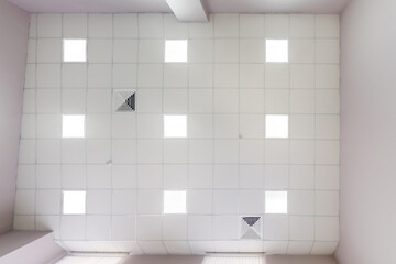 cassette stretched or suspended ceiling with square halogen spots lamps and drywall construction in...