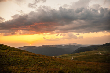 Romania Transalpina road with many serpentines crossing forest in  Carpathian mountains. Mountains forest trees with road in Parang mountains