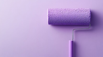 Obraz premium Purple paint roller on purple background with copy space.