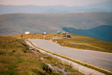 Sunset on Romania Transalpina road with many serpentines crossing forest in  Carpathian mountains. Mountains forest trees with road in Parang mountains