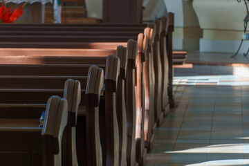 Benches in the Catholic church. The interior of the church. Places for temple visitors to pray.