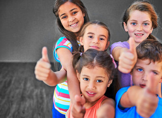 Children, group and thumbs up in portrait at school for learning success, education approval and yes to knowledge. Students, kids and diversity with hand gesture for thank you, agreement and happy