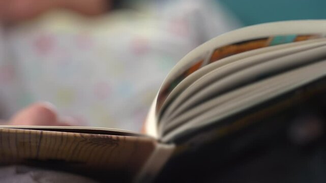 Close-up of an open book being read, capturing a quiet moment of focus and storytelling