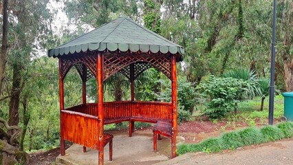 Red gazebo surrounded by greenery in the botanical garden