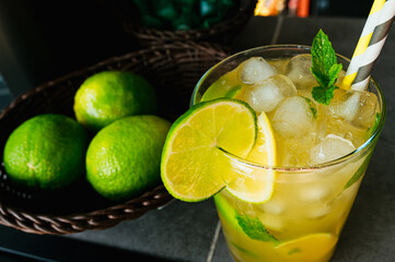Mojito cocktail, typical Cuban rum-based soft drink, served in a pub with limes.
