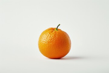 A single orange sits on a plain white surface