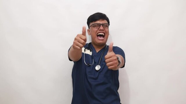 Confident asian male doctor with stethoscope giving thumbs up against a white background
