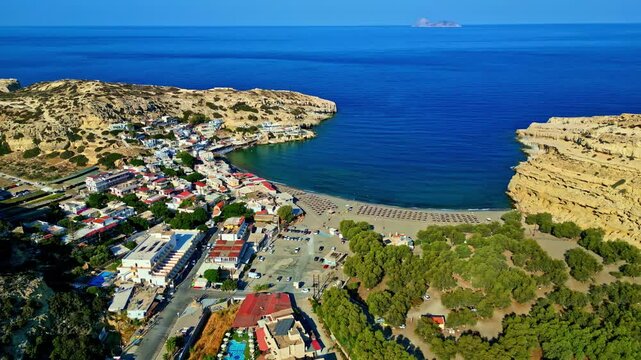 Aerial View Of Matala Beach, Hotels, Blue Sea And Campground On A Sunny Day In Matala, Pitsidia, Greece.