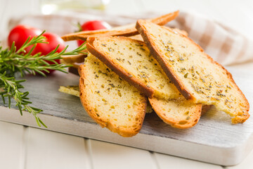 Crispy roasted bruschetta bread on cutting board.