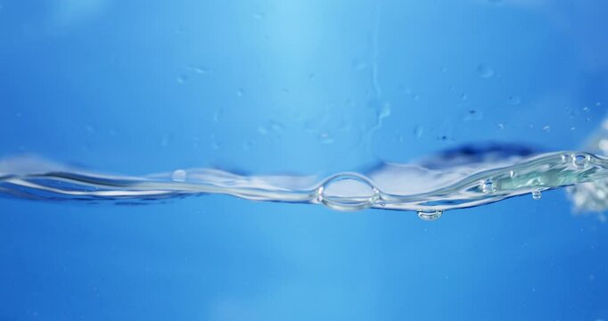 Waves of sparkling water, create some bubbles and droplets in a container.