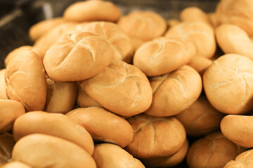 Fresh Kaiser rolls stacked on a store shelf. Group of classic bread rolls on display. Bakery section with a pile of golden brown buns. Perfect for sandwiches or breakfast. Crisp, freshly baked roll.