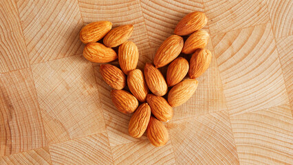 Almonds on a wooden table in the shape of a heart. Healthy nutrition. Diet
