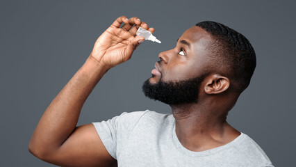 Black guy applying ophthalmology eyedropper. Glaucoma eye prevention, human vision serum wash