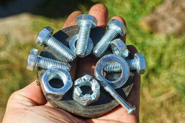 a small iron round powerful black magnet with a bunch of different chrome industrial shiny new nuts...