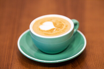 cappuccino in a blue cup with a heart on the table. Good morning