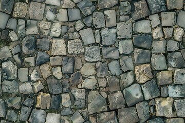 Obraz premium Cobblestone stone road pavement featuring various shapes and sizes of stones in shades of gray and brown. The stones are arranged in a seemingly random pattern, showcasing.