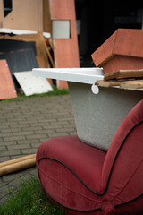 The unwanted red sofa and bathtub were taken to the trash. Old furniture in dump