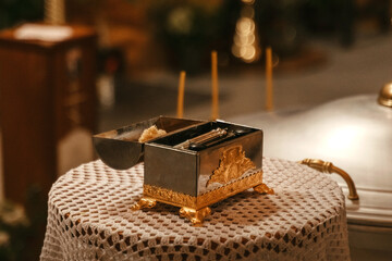 Illuminating Grace: A Table Adorned With a Metal Box and Glowing Candles