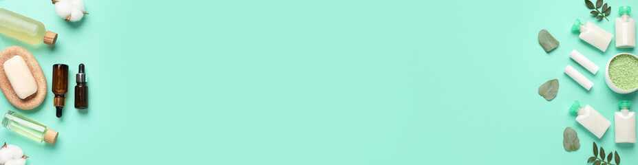 Cosmetic products and cotton flowers on turquoise background, flat lay. Banner design with space for text