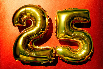 Golden balloons shaped as numbers 25 on red background