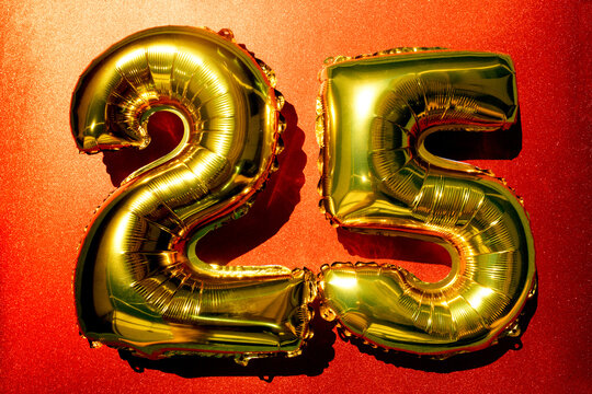 Golden balloons shaped as numbers 25 on red background