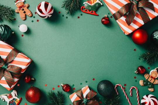 Festive Christmas flat lay composition featuring gifts, ornaments, and candy canes on a green background. Vintage style