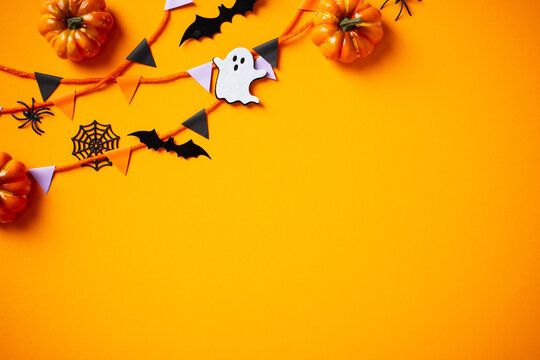 Festive Halloween decor on orange background. Perfect for seasonal promotions and holiday backgrounds. Engage with spooky charm