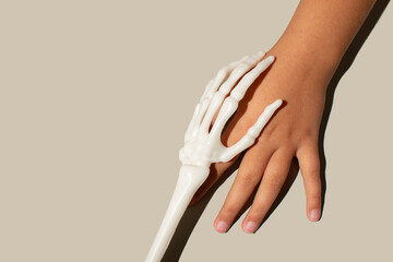  Skeleton hand touching human hand, scarey concept. halloween idea.