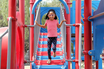 5 year old Latina brunette girl with glasses plays in the park games as therapy for autism and ADHD