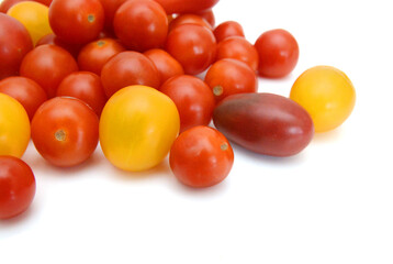 Mini black, red, and yellow tomatoes isolated on white