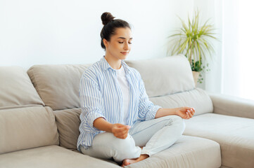 Relaxation in the morning. Calm pretty young arabian or indian woman in a cozy living room, sitting...