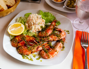 Image of delicious king shrimps and salad from potatoes at plate