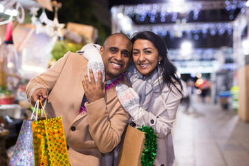 Naklejka premium Husband and wife with gifts walk in the new year street fair