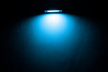 Hanging led Lamp On concrete wall. blue Lights and shadows. night scene.