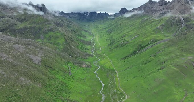Aerial footage of beautiful high altitude snow capped mountain and grassland landscape
