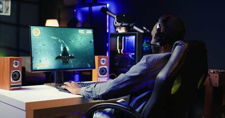 Man feeling happy while playing science fiction videogames on computer desktop, celebrating victory. Cheerful gamer overjoyed after winning game on gaming PC, close up, camera B